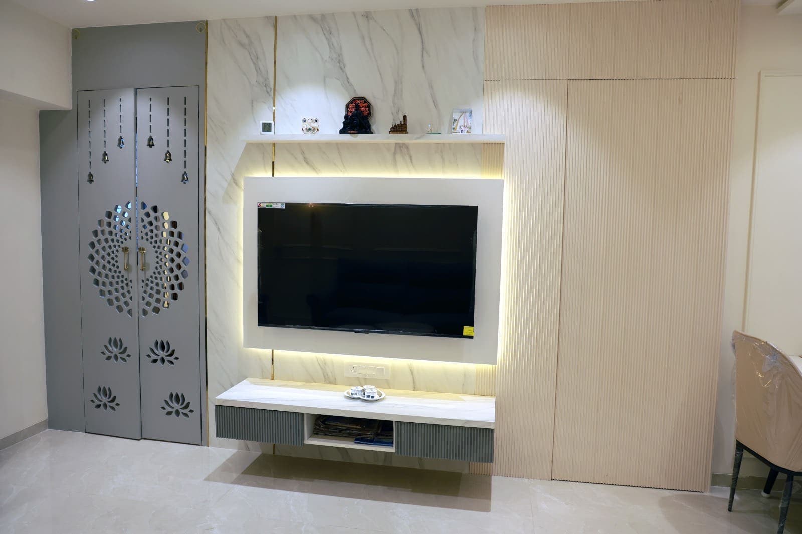 Media wall with laser-cut jaali side panels and hanging bells